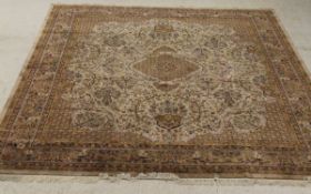 An Indian rug, the central panel set with floral decorated medallion on a mushroom coloured ground,