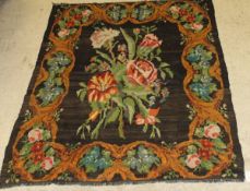 A Caucasian Kelim rug, the central panel set with floral spray design on a black ground,