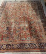 A Ziegler carpet, the central panel set with all over floral decoration on a terracotta ground,