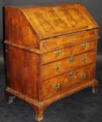 An 18th Century walnut bureau, the cross-banded top above a sloping fall with feather-banding,