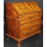 An 18th Century walnut bureau, the cross-banded top above a sloping fall with feather-banding,