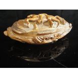A 19th Century carved and hinged lidded betel nut box of oval form,