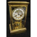 A gilt brass four glass mantle clock by J W Benson with two piece white enamel dial,