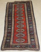 A Kasak runner, the central panel set with ten repeating medallions on a terracotta ground,