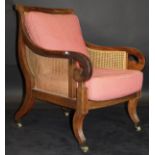 An early 19th Century mahogany framed bérgère armchair with caned seat,