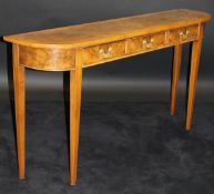 A walnut side table, the figured top feather and cross-banded over three frieze drawers,
