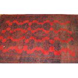 A Donegal carpet, the central panel set with repeating designs in blue and green, on a red ground,