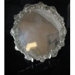 A George III silver salver with pie crust and shell border raised on three hooved feet (possibly by