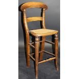 A 19th Century stained beech child's deportment chair with bar back, caned seat,