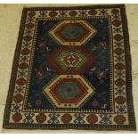 A Caucasian rug, the central panel set with three lozenge shaped medallions within a blue ground,