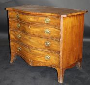 A George III serpentine fronted mahogany chest of four graduated drawers with brass embossed oval