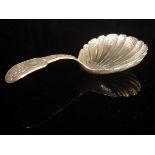 A George IV silver caddy spoon with shell-shaped bowl and embossed foliate and shell decoration