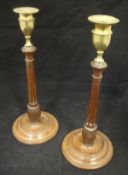 A pair of George III mahogany candlesticks with brass socles on a turned and fluted column to a