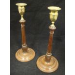 A pair of George III mahogany candlesticks with brass socles on a turned and fluted column to a