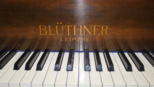 A walnut cased baby grand piano, the iron framed over strung movement by Blüthner of Leipzig,