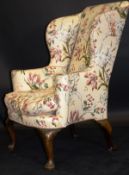 An early 18th Century upholstered wing back scroll arm chair,