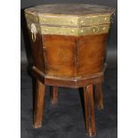 An early 19th Century mahogany and brass bound wine cooler of octagonal tapered form with twin lion
