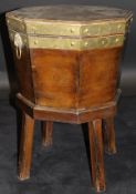 An early 19th Century mahogany and brass bound wine cooler of octagonal tapered form with twin lion