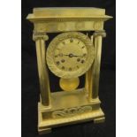 A French Regency period lacquered brass cased mantle clock with Ionic column supports,