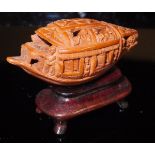 A Chinese betel nut carving as a boat with movable shutters to the sides, 4 cm long,