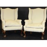 A pair of 19th Century upholstered wing back scroll arm chairs in the George III taste,