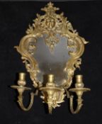 A brass girandole mirror in the Louis XV taste with sunburst mask finial over a shaped frame with