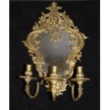 A brass girandole mirror in the Louis XV taste with sunburst mask finial over a shaped frame with