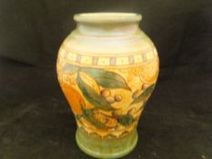 A Charlotte Rhead Bursley Ware vase decorated with band of fruit and flowers on a terracotta ground