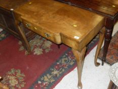 A 1930's walnut and cross banded single drawer side table raised on cabriole legs to pad feet
