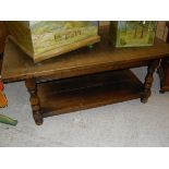 A modern oak two tier coffee table on baluster turned supports to turned feet