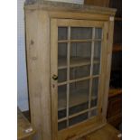 A pine hanging corner cabinet with glazed and barred door