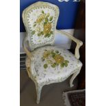 A pair of Louis XVI style open arm chairs with painted frames and floral upholstery