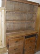 A Victorian pine dresser with two tier boarded plate rack over two cupboard doors as two banks of
