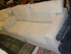A modern cream three piece suite comprising two seat sofa,