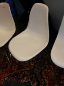 A set of three chrome framed white plastic kitchen chairs after the original designs by Charles and