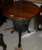 A pair of Victorian cast iron based pub tables with circular mahogany tops