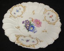 A Meissen plate with central floral spray decorated with cross swords to the base,