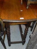 An oak drop-leaf oval dining table with barley twist supports, an elm seated stick back chair,