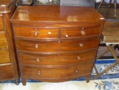 A Victorian mahogany bow fronted chest of two short over three long graduated drawers with turned