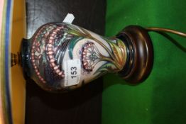 A Moorcroft table lamp base on a violet ground decorated with stylised flowers