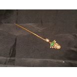 A yellow metal stick pin with diamond emerald and seed pearl decoration