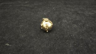 A 9 carat gold Masonic ball pendant opening to reveal a cross engraved with various Masonic symbols,