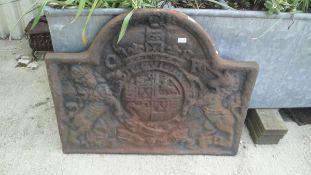A cast iron fireback decorated with proud lion and chained unicorn bearing a Royal coat of Arms