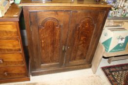 A 19th Century oak two door cupboard enclosing shelves,