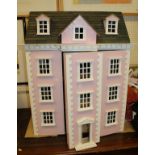 A painted pink dolls town house with varrious furniture etc.