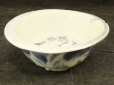 A Ming Dynasty Chinese blue and white bowl with flared rim on a circular foot with all over foliate