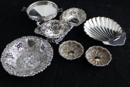 A collection of three pierced silver bonbon dishes, two embossed silver salts,