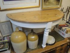 A pine and painted demi lune table with turned legs plank top and white painted base together with