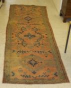 A Turkish Ushak runner, the central panel set with repeating geometric design on a red ground,