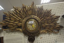 A Smith's wall clock with Roman numerals to the dial set in a carved giltwood starburst frame,